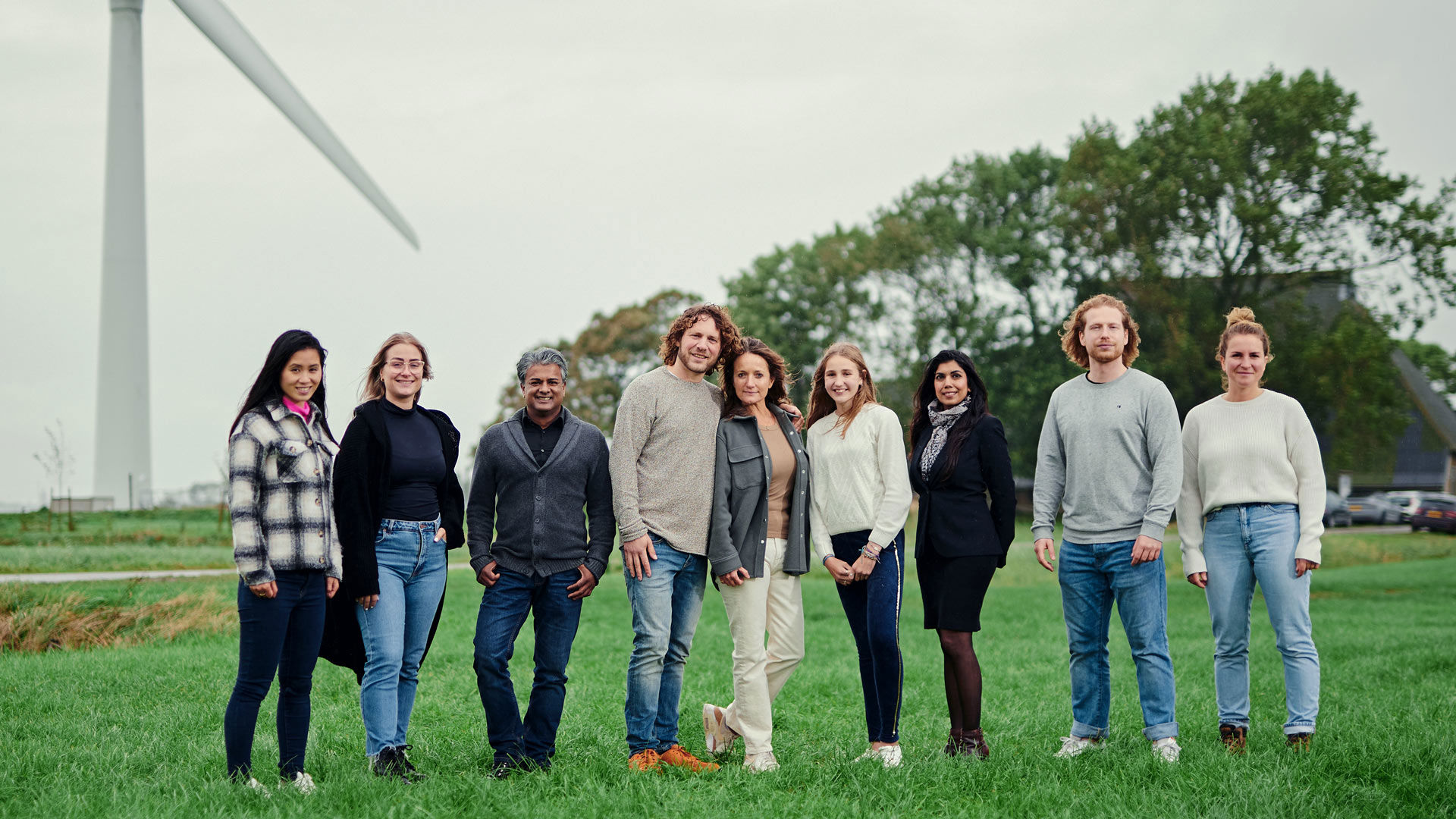 Groep mensen op een rij voor een windpark