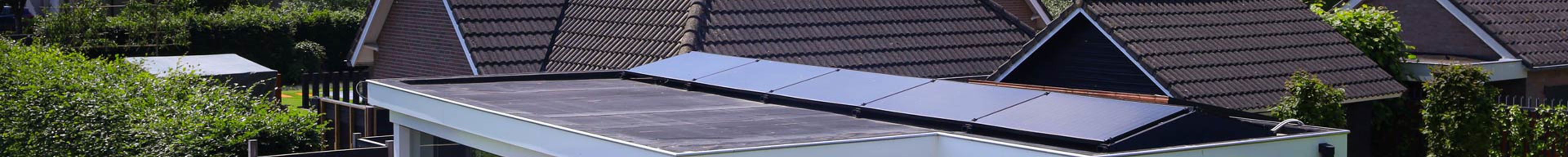 Zonnepanelen schuin geplaatst op een plat dak van een bijgebouw van een vrijstaande woning