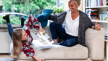 Twee vrouwen lachend op een bank