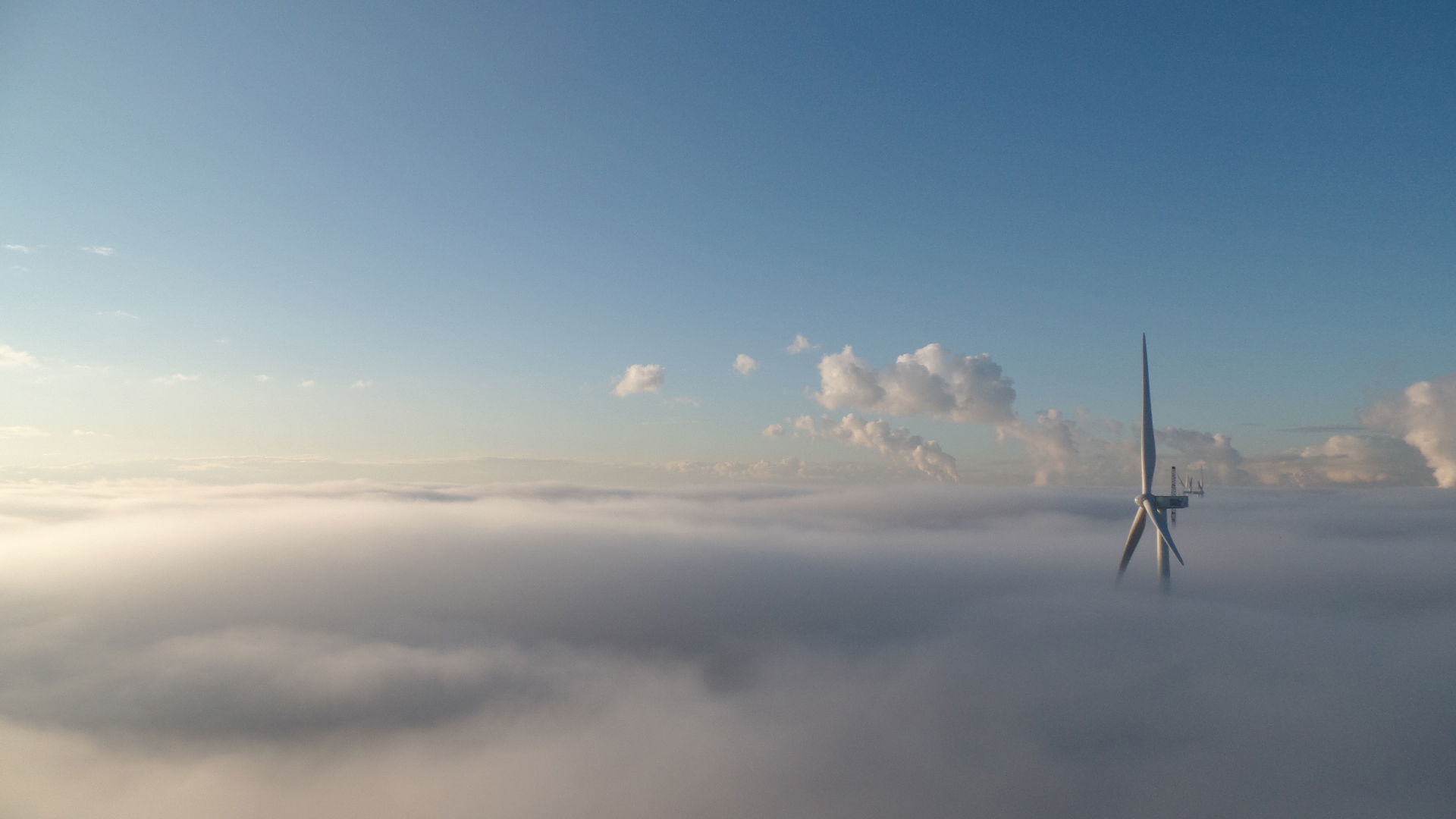 Windmolen die boven de mist uitkomt